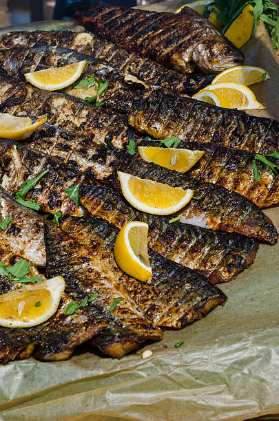 Grilled sea fish with lemons and greenery