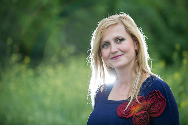 istock Smiling blonde woman in spring meadow 537297594