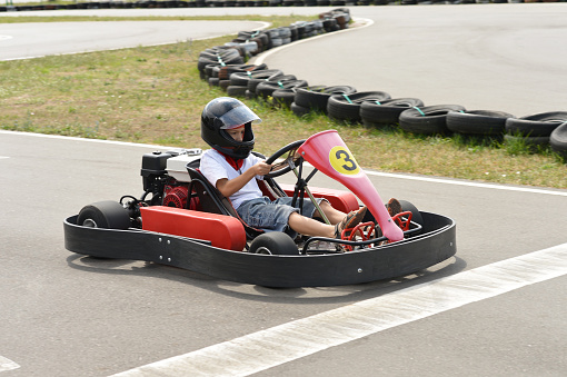 Teenage boy sitting in go-kart at an outdoor track