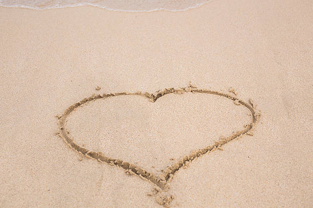 istock Heart drawn in the sand. Beach background. Top view 537300558