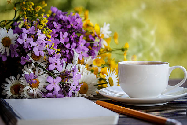 istock notebook, flowers and cup of coffee on the desk 537302524