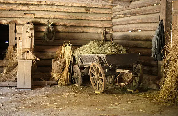 Photo of Wooden cart with hay in old barn.