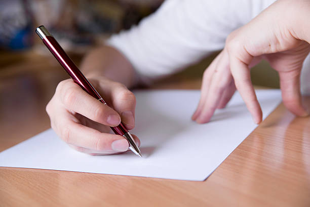istock elementary school student writing on the paper with pen 537305390
