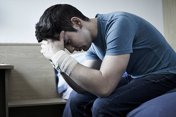Depressed Young Man With Bandaged Wrists After Suicide Attempt Depressed Young Man With Bandaged Wrists After Suicide Attempt self harm photos stock pictures, royalty-free photos & images