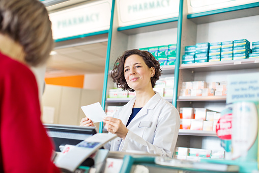 Male Customer Showing Name Of Medicine From Smartphone