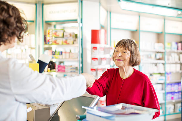 kunden erhalten sie medikamente von apothekerberuf - pharmacy pharmacist smiling pill stock-fotos und bilder