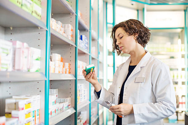 Female pharmacist taking medicine from shelf