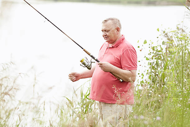 istock Mature angler catching fish on lake 537309630
