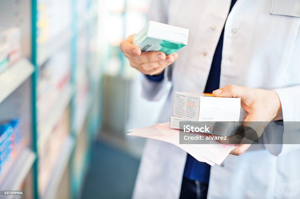 Pharmacist's hands taking medicines from shelf Closeup of pharmacist's hands taking medicines from shelf at the pharmacy Pharmacy Stock Photo