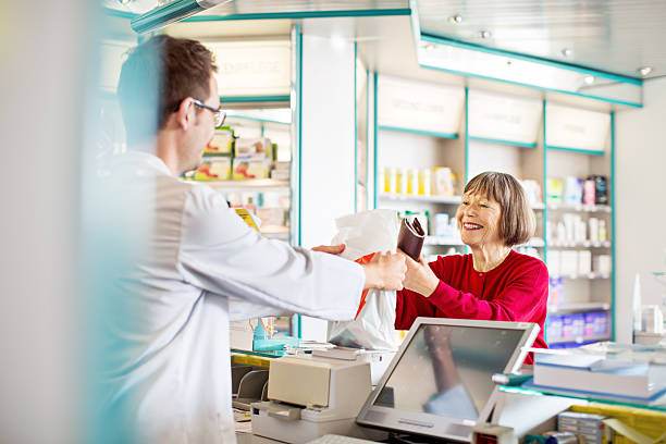 薬剤師のギブ処方薬を顧客 - pharmacy pharmacist smiling pill ストックフォトと画像