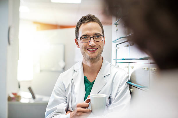 détendue jeune mâle pharmaciens avec une tasse de café - scientist male young adult doctor photos et images de collection