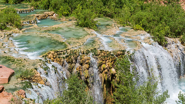 Little Navajo Falls and Travertine Pools Water from Havasu Creek flows over travertine pools and rushes over Little Navajo Falls on the Havasupai Indian Reservation in the Grand Canyon. harasu canyon stock pictures, royalty-free photos & images