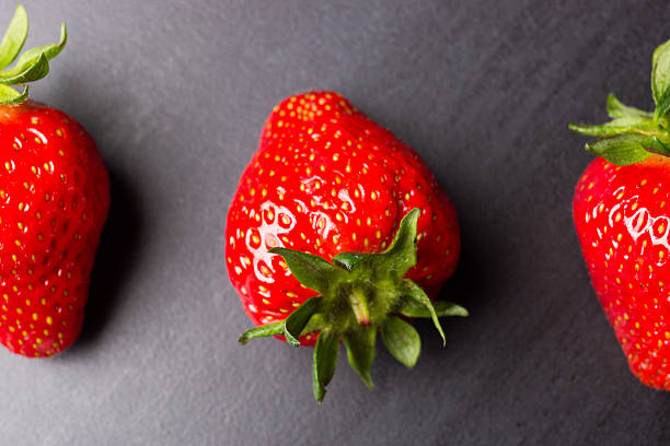 istock tasty strawberries isolated on black background, stone tile 537313668