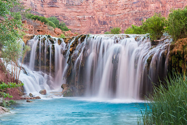 Little Navajo Falls on and Turquoise Havasu Creek Silly water flows over Little Navajo Falls into a turquoise pool on the Havasupai Indian Reservation in the Grand Canyon. harasu canyon stock pictures, royalty-free photos & images