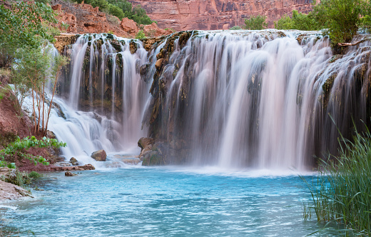Silly water flows over Little Navajo Falls into a turquoise pool on the Havasupai Indian Reservation in the Grand Canyon.