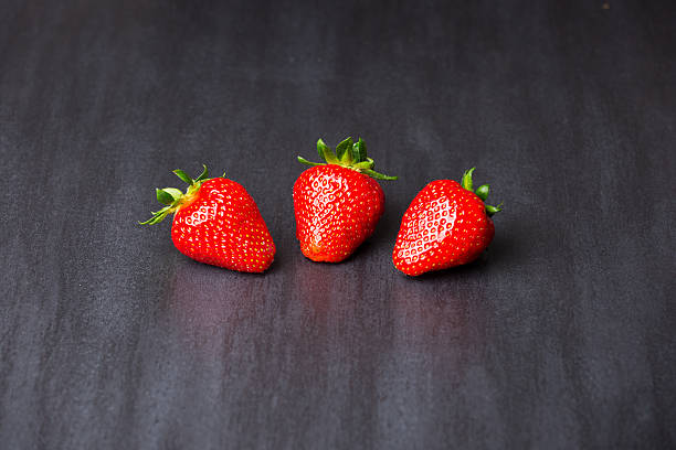 istock tasty strawberries isolated on black background, stone tile 537314532