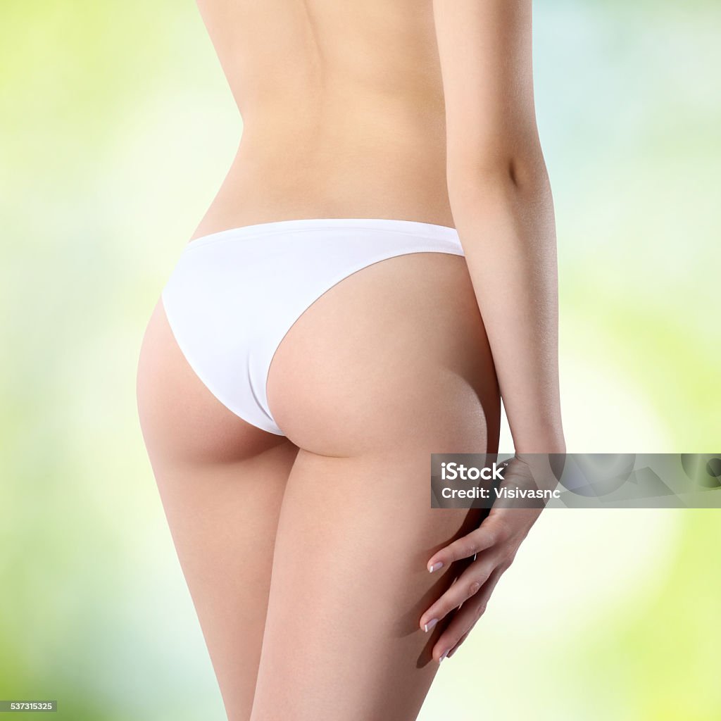 Fesses de femme en culotte blanche sur fond vert - Photo de Fesses libre de droits