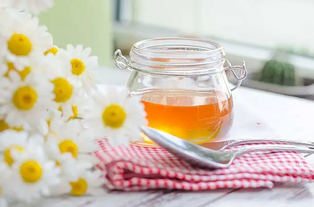 Honey can with daisy flower