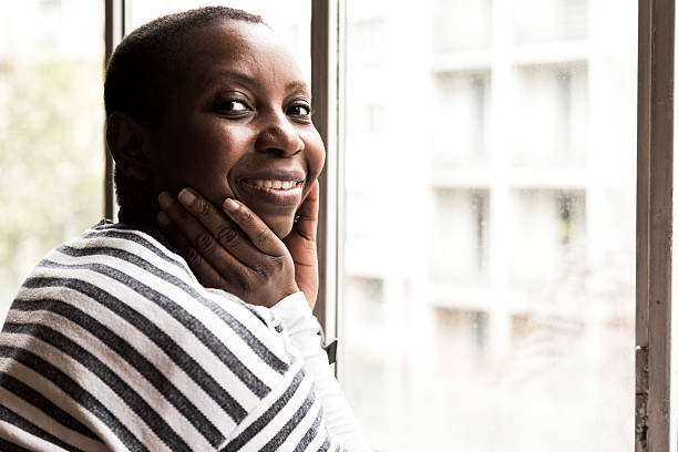 istock Young black woman looking through window 537315924