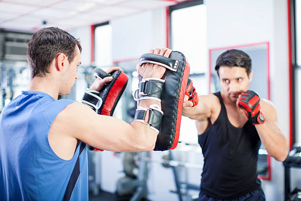 Two men working out punches in gym stock photo