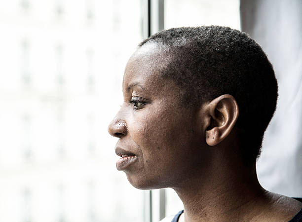 istock Young black woman looking through window 537316142