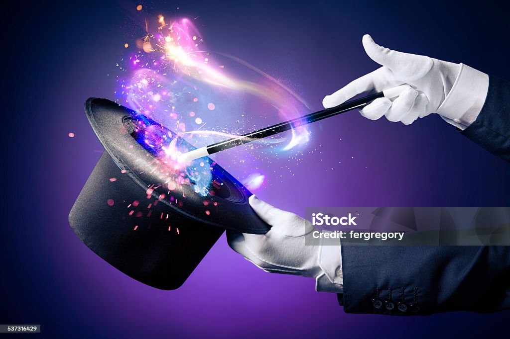 High contrast image of magician hand with magic wand Magician hand with magic wand and hat Magician Stock Photo
