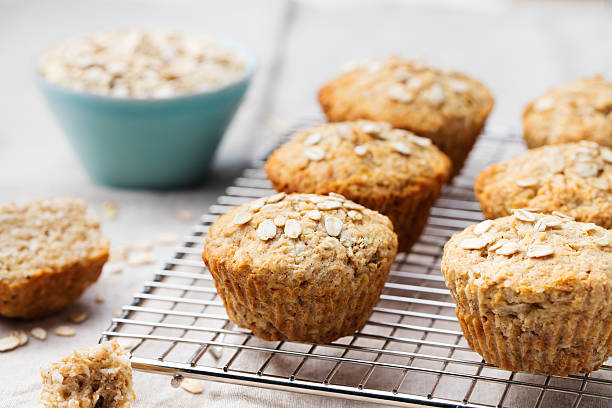 Healthy vegan oat muffins, apple, banana cakes on cooling rack Healthy vegan oat muffins, apple and banana cakes on a cooling rack Grey textile background whole wheat stock pictures, royalty-free photos & images