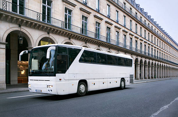 Bus on a street in Paris, France A white bus is standing in front of arcades on a street in Paris, France coach bus photos stock pictures, royalty-free photos & images