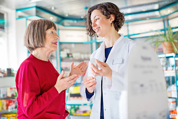 consulenza donna anziana con il farmacista venda il medicinale dosaggio - retail shopping talking customer foto e immagini stock