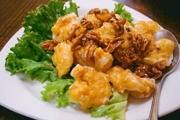 Lightly battered prawns served with candied walnuts stock photo
