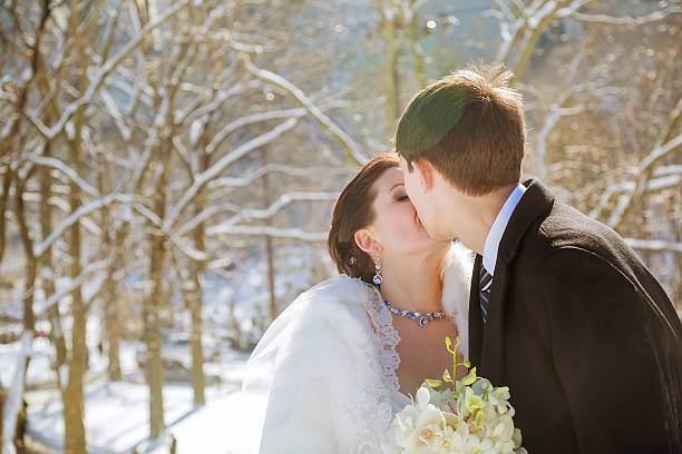 istock bride and groom in the park winter 537320632