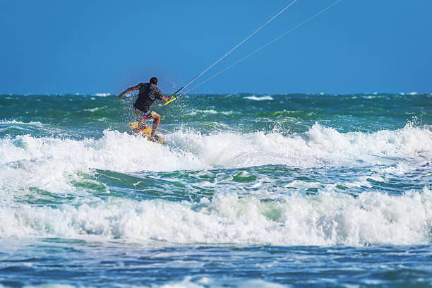 istock Athletic man riding on kite surf board at sea waves 537323510