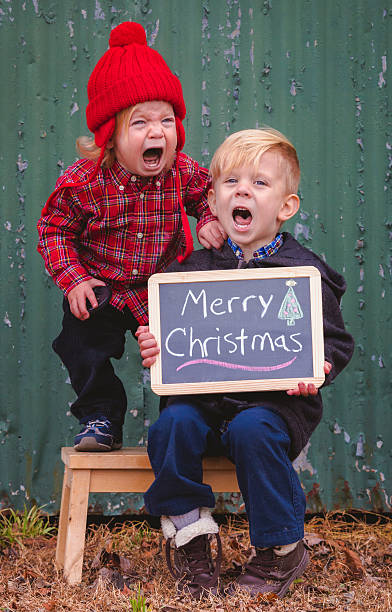 Children Crying for Christmas Photo Two boys object to having their picture taken. negative emotion photos stock pictures, royalty-free photos & images