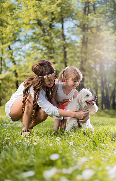 istock Young mother and daughter enjoying in a day with poodle. 537337096