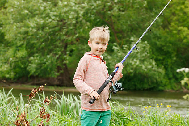 istock Photo of little kid pulling rod while fishing on weekend 537337456