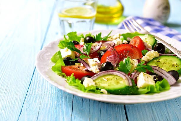 une salade grecque traditionnelle sur une plaque blanche. - greek culture salad olive feta cheese photos et images de collection