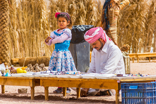 Sharm El Sheikh, Egypt - May 07, 2014: Bedouin and his daughter keep souvenir shop in desert.