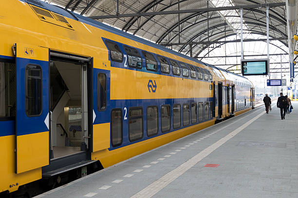 Passenger train of the Dutch Railways (NS) at Zwolle station Zwolle, The Netherlands - April 3, 2016: Passenger train of the Dutch Railways (NS)  at the Zwolle train station during. People are walking towards their train on the platform. commuter train photos stock pictures, royalty-free photos & images