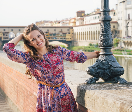 Portrait of happy woman on the embankment near Ponte Vecchio