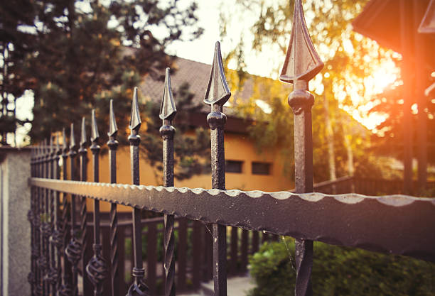 Wrought iron fence Nice wrought iron fence in afternoon backlight. parallel photos stock pictures, royalty-free photos & images
