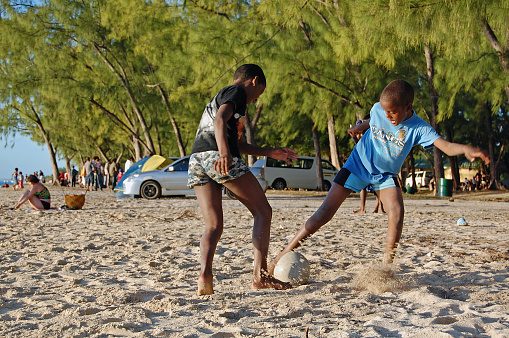Le Morne, Mauritius. August 1, 2010. Two mauritian boys play one on one soccer in the sand on a mauritian beach