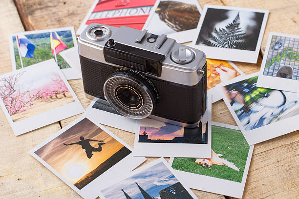 istock Old analog camera with real photos over wooden table 537346093