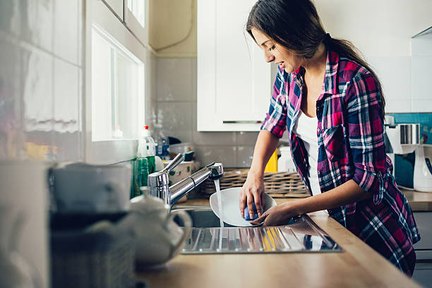 Dish washing Beautiful young woman washing dishes. Shot made during Istockalypse Paris 2016 event. washing dishes stock pictures, royalty-free photos & images