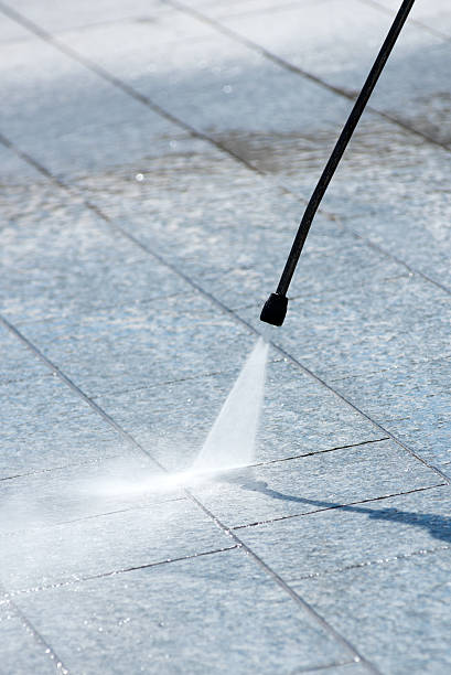 istock Using a pressure hose to power clean paving 537348178