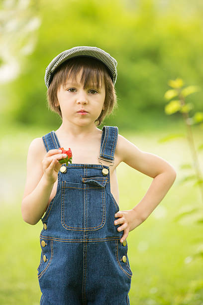 niedlich schönen kind, junge, essen erdbeeren und im park - child portrait fine art portrait multi colored stock-fotos und bilder