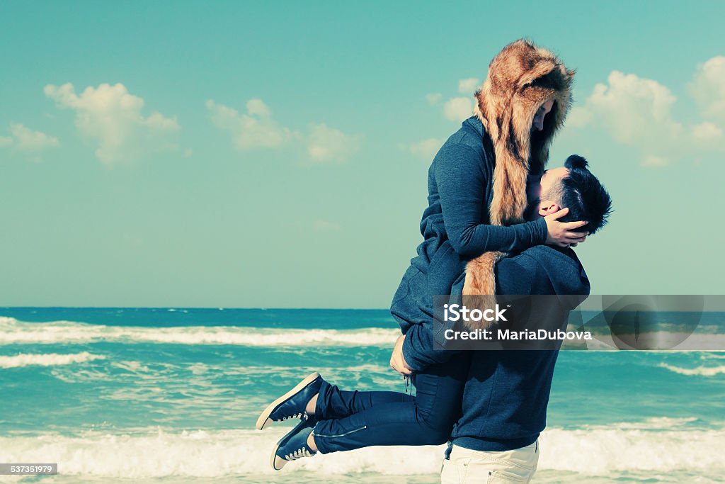 Beautiful young couple relaxing outdoor Beautiful young couple relaxing outdoor at winter beach Couple - Relationship Stock Photo
