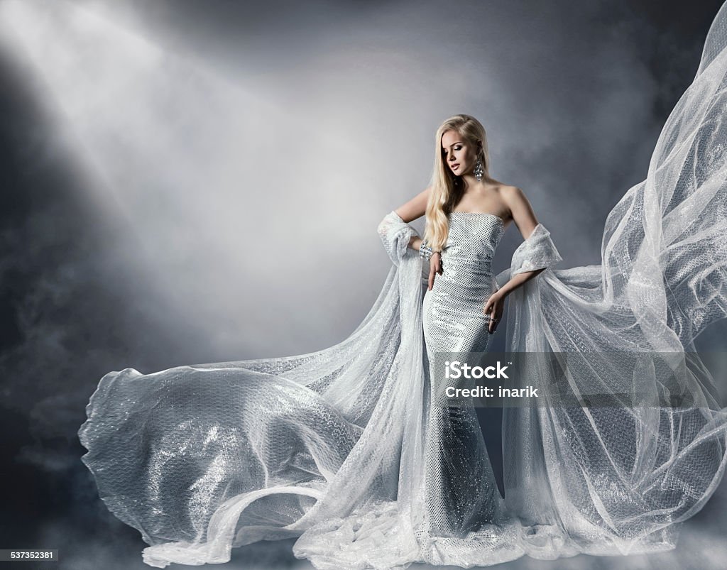 Young Woman Fashion Shiny Dress, Lady Flying Clothes, Star Light Young Woman in Fashion Shiny Dress, Lady in Flying Clothes, Girl under Star Light, Shiny Cloth Fluttering and Flowing Silver Colored Stock Photo