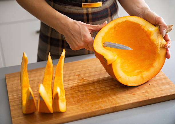 istock closeup on young housewife cutting pumpkin 537352561