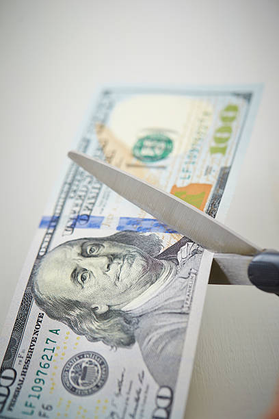 istock Trying to cut US dollar bill with scissors 537353738