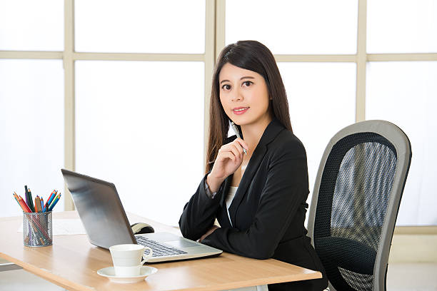 istock Smiling Asia entrepreneur using laptop and drink coffee at desk 537355770